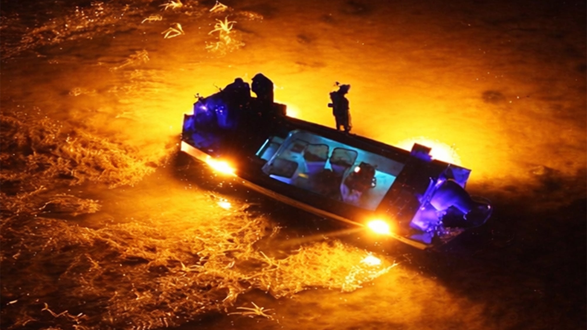 Bowfishing boat illuminated by high-output bowfishing lights attracting fish at night